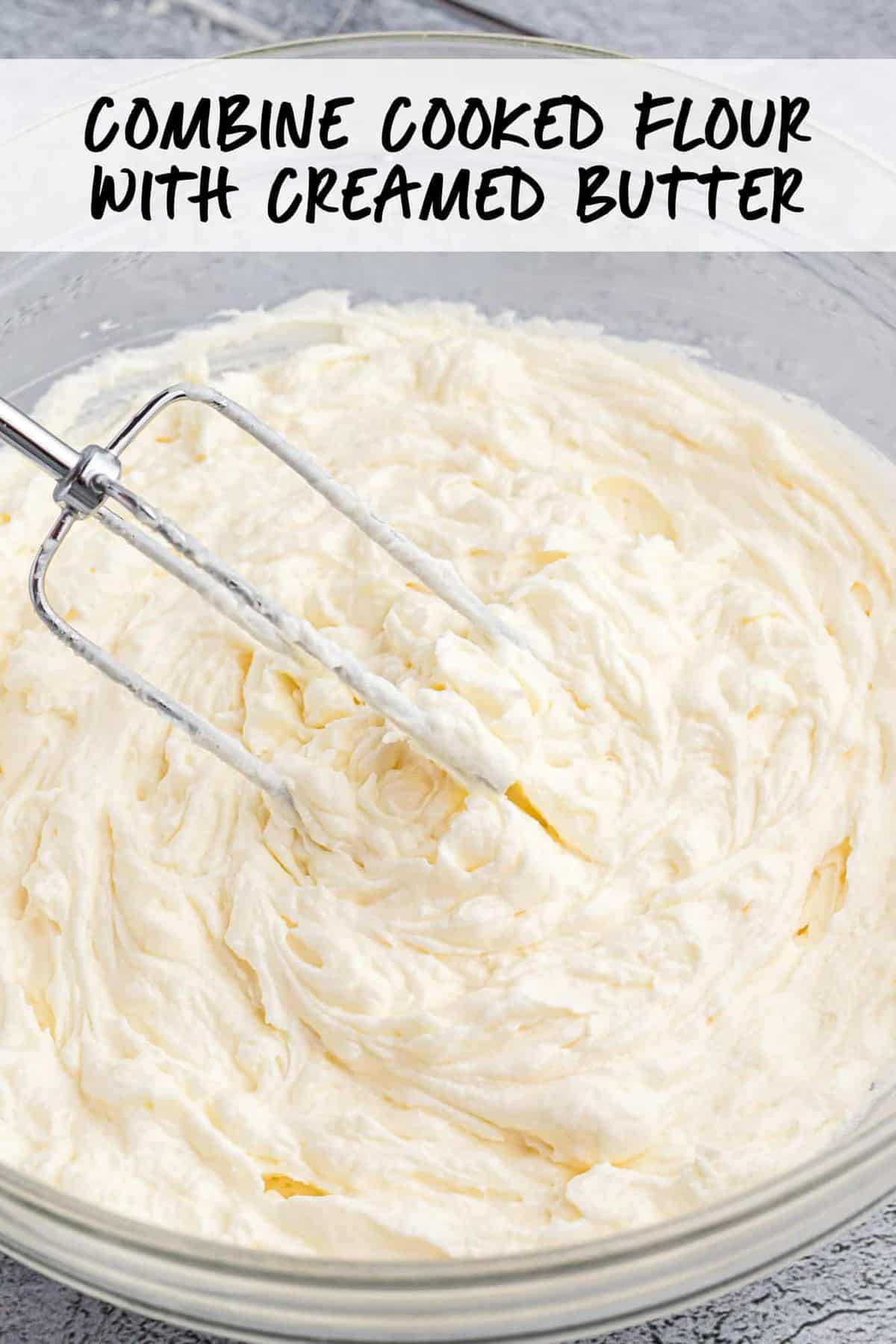 whipped icing in glass bowl with beater.