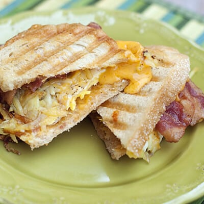 A bacon and egg panini on a decorative plate