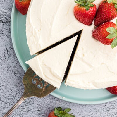 cut cake topped with whipped frosting and strawberries.