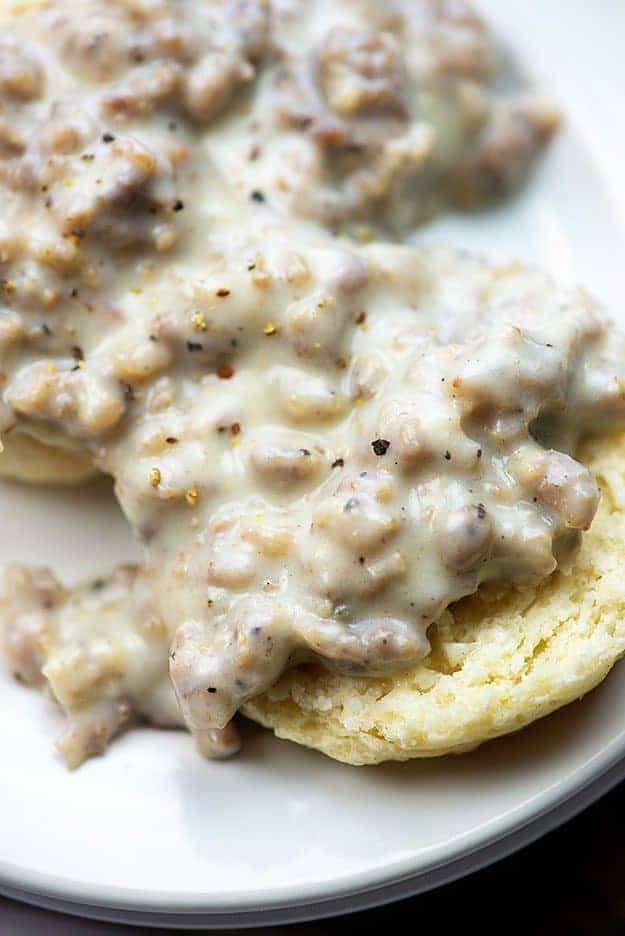 Close up of a biscuit topped with sausage gravy.