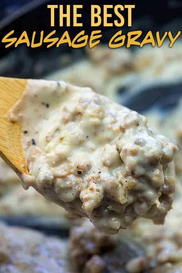 Wooden spoon holding up sausage gravy to the camera.