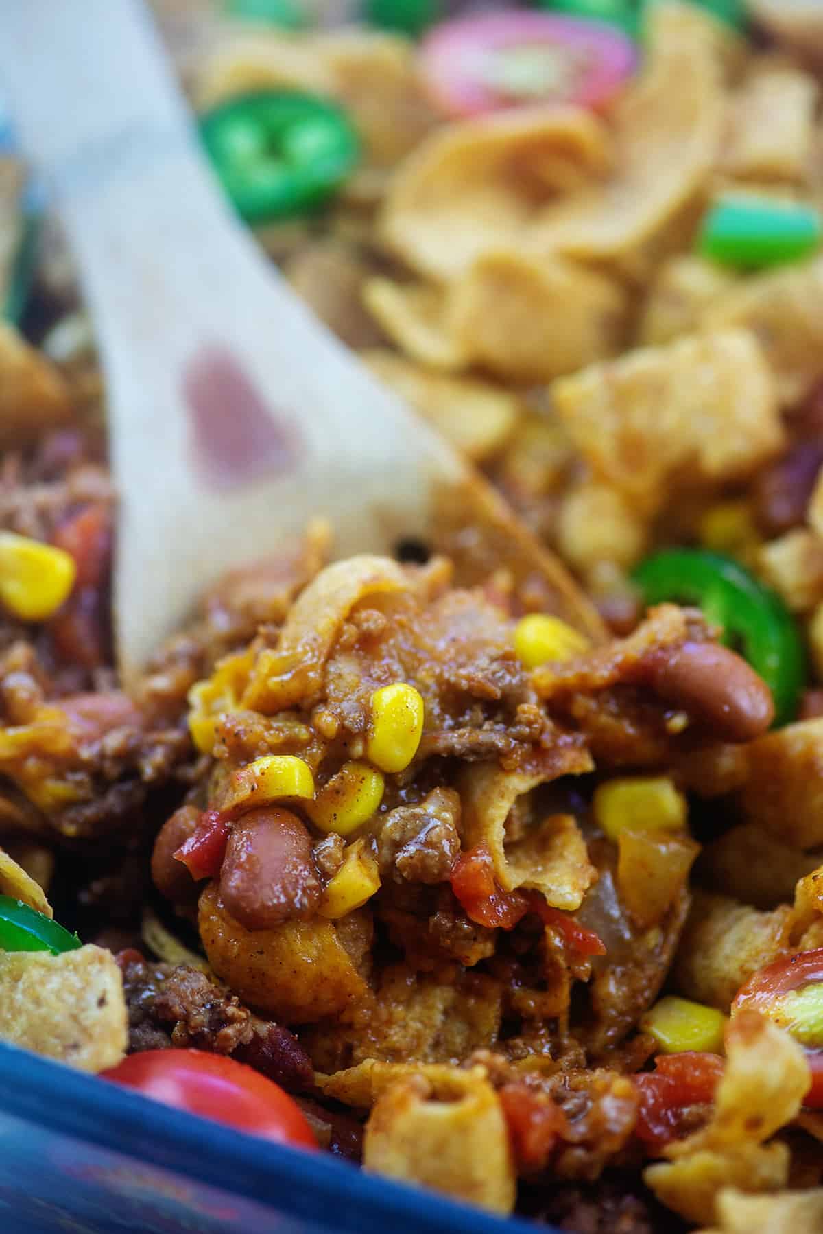 wooden spoon full of baked Frito pie.