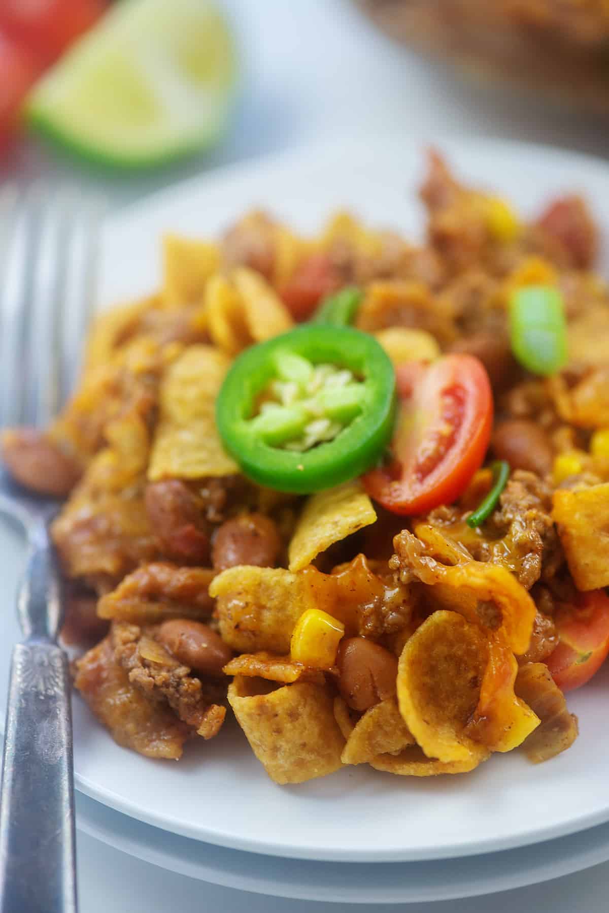 Frito pie recipe on white plate.