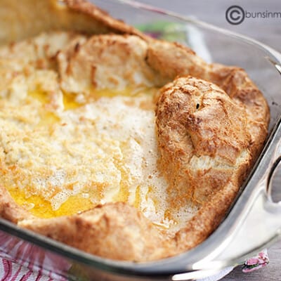 Cooked dough and melted butter in a clear glass baking dish.