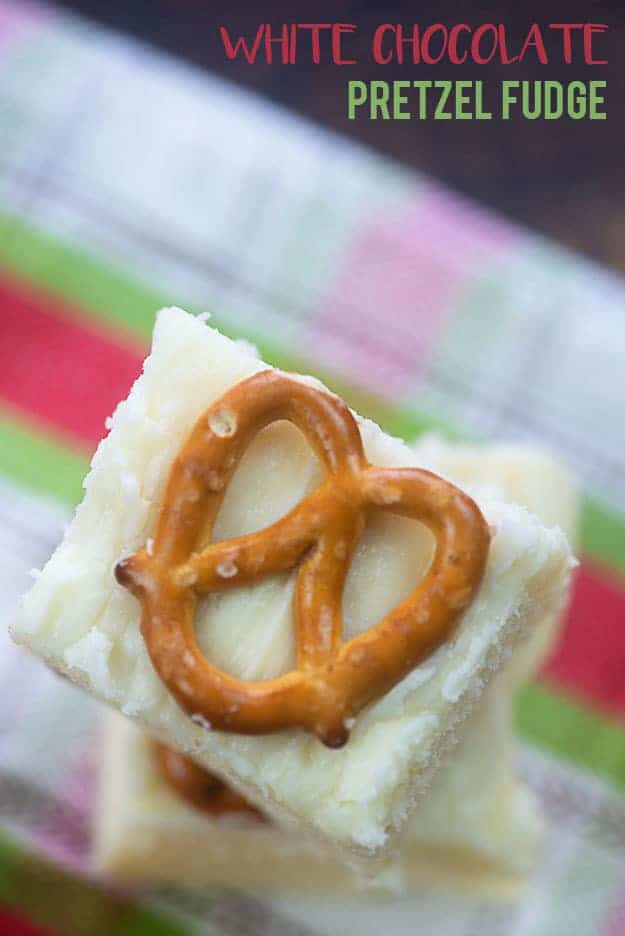 A close up of white fudge with a mini pretzel on it.