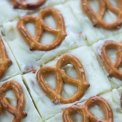 Several squares of white fudge with pretzels on top.