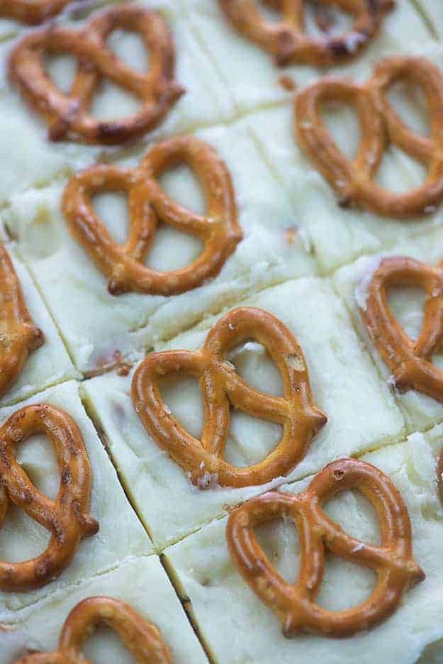 Several squares of white fudge with pretzels on top.