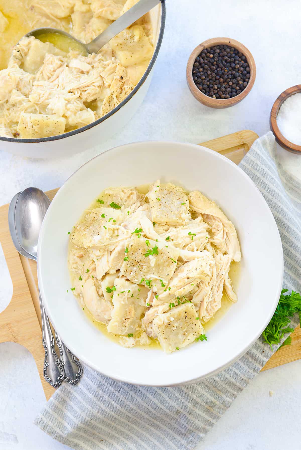 overhead view of chicken and dumplings in white bowl.