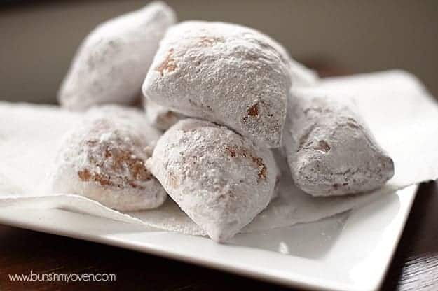 Beignet donuts stacked up on a white plate
