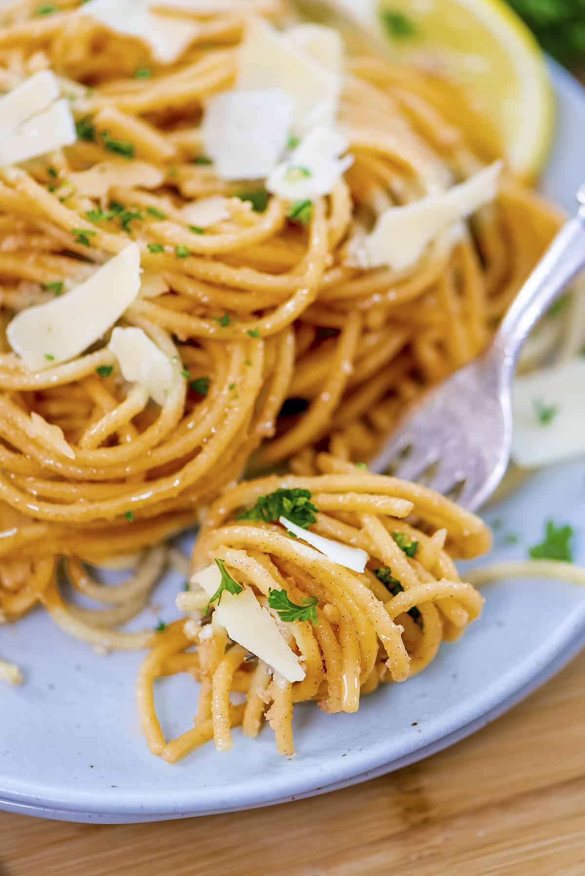 Browned butter lemon garlic pasta twirled on fork.