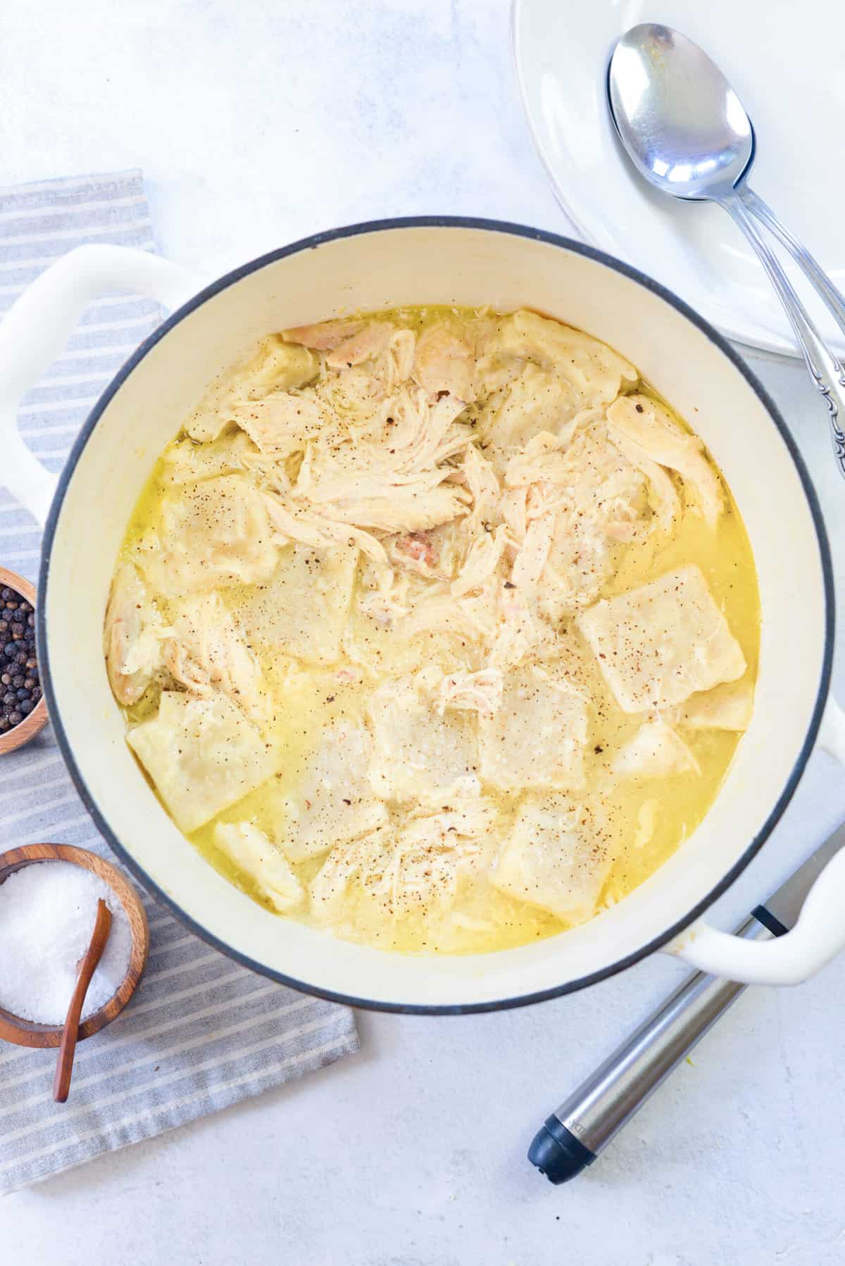 chicken and dumplings in white dutch oven.