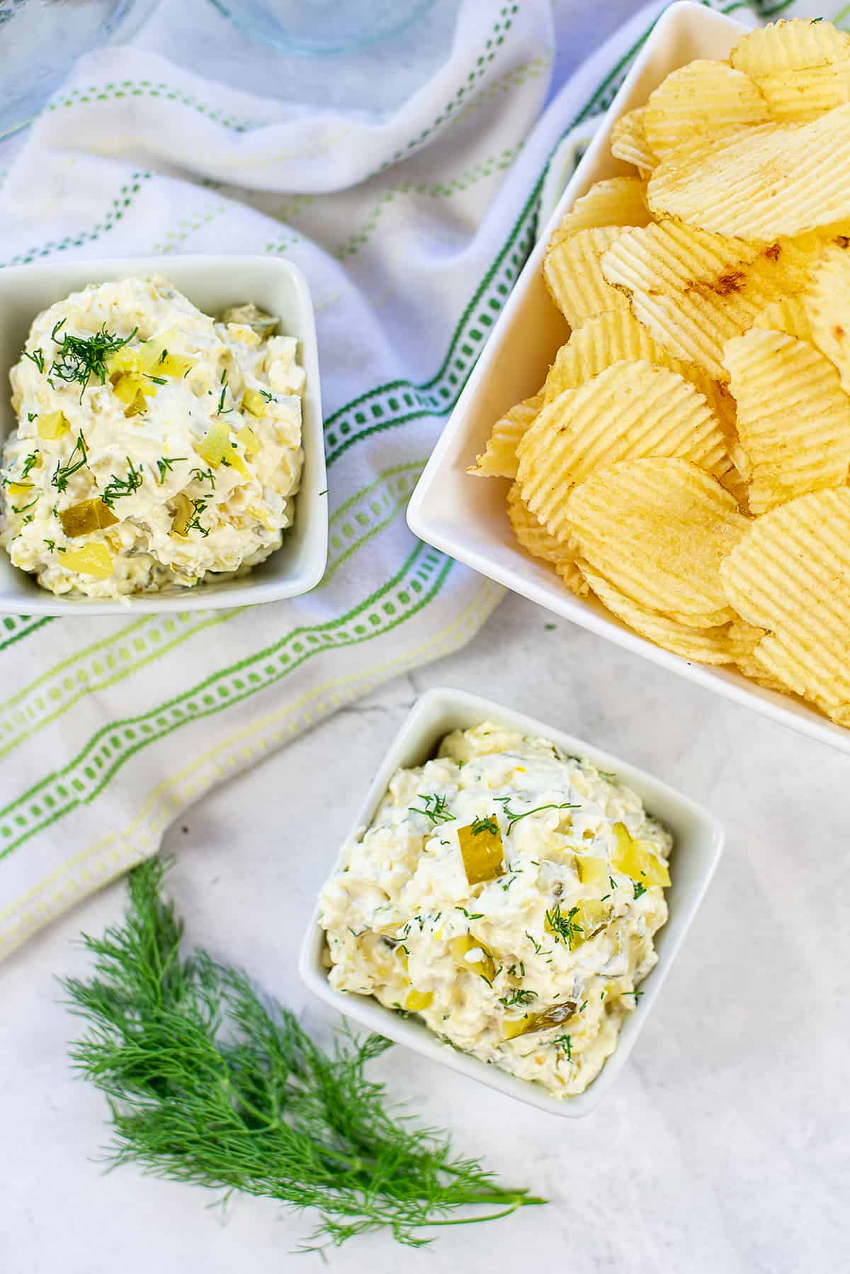 dill pickle dip in small bowls with chips.