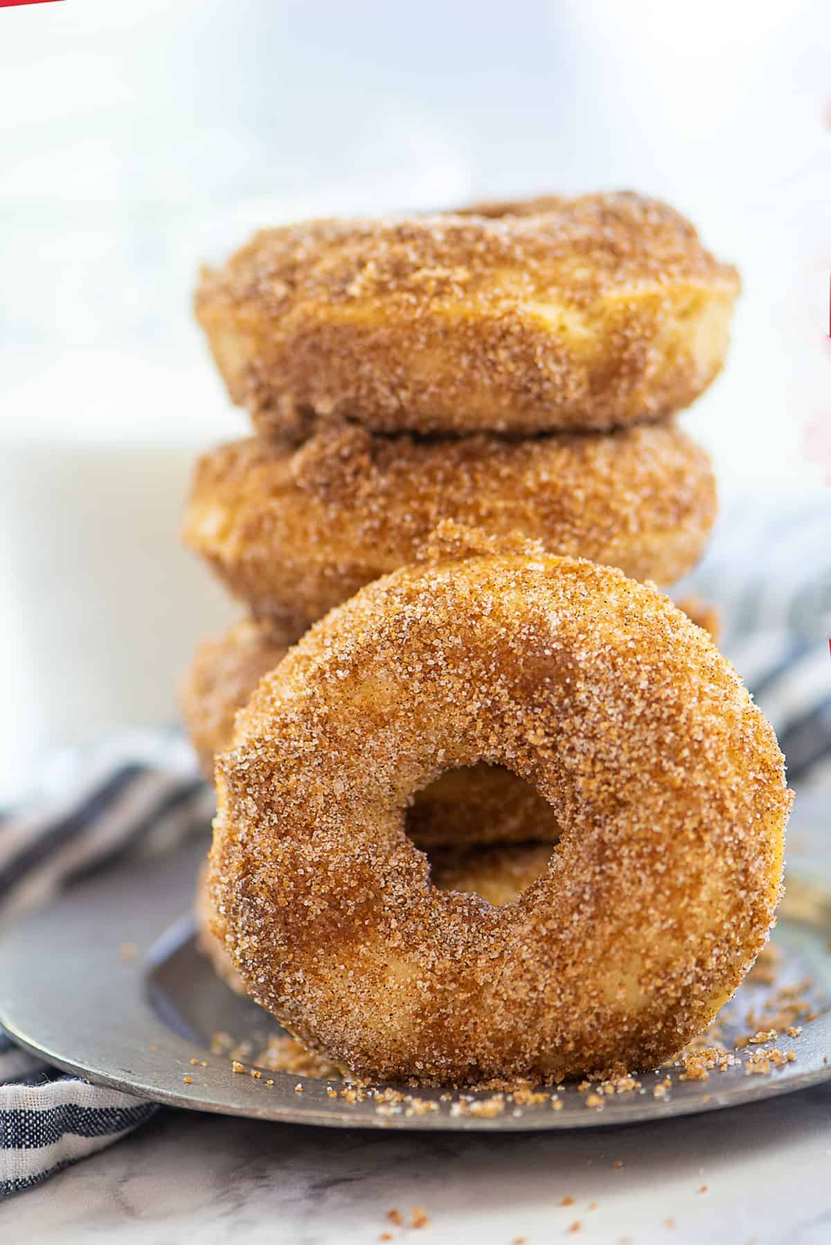 cinnamon sugar donuts on silver plate in a stack.