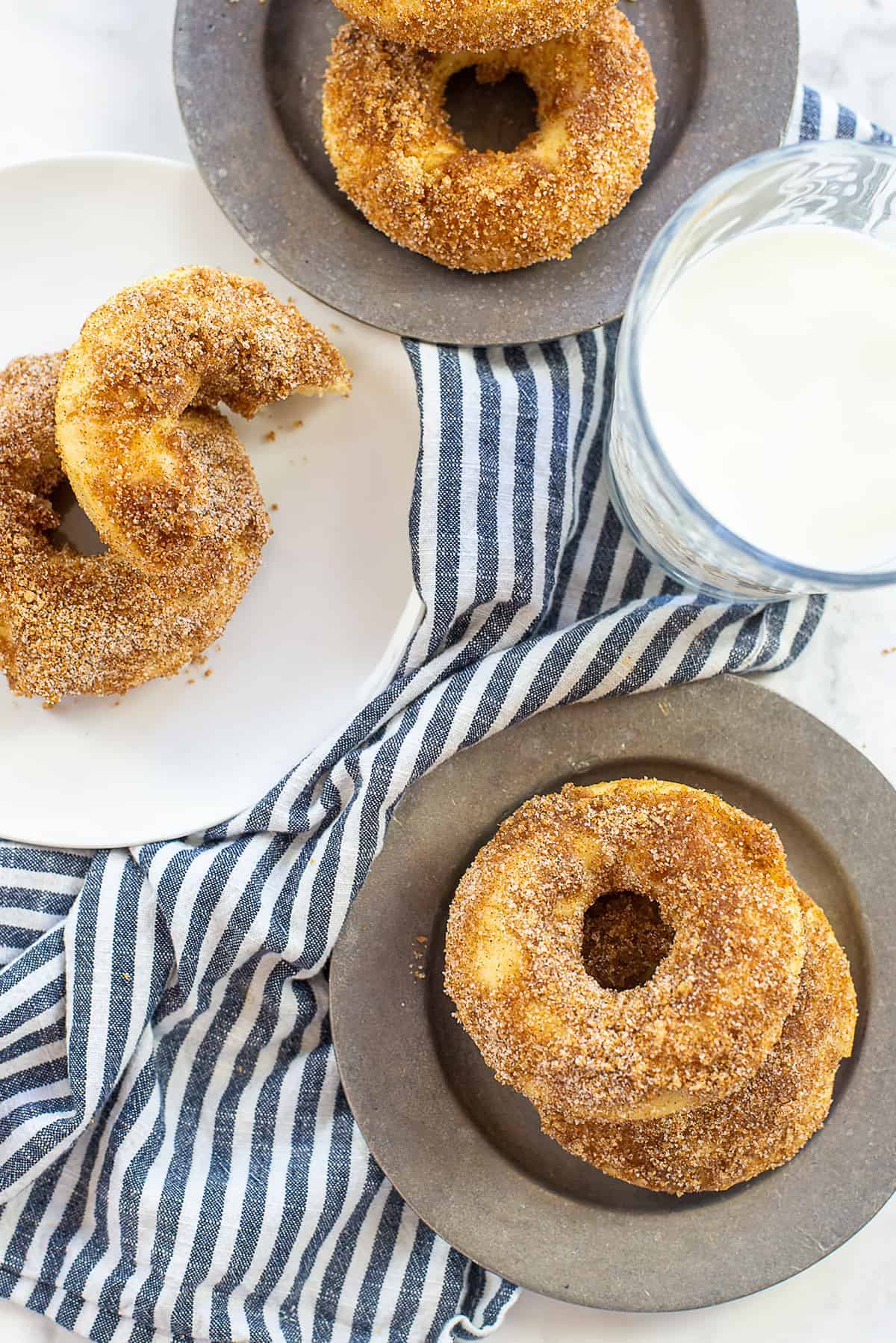 cinnamon sugar donuts on silver plates.