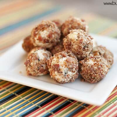 Stacked cheese bacon balls on a square white plate.