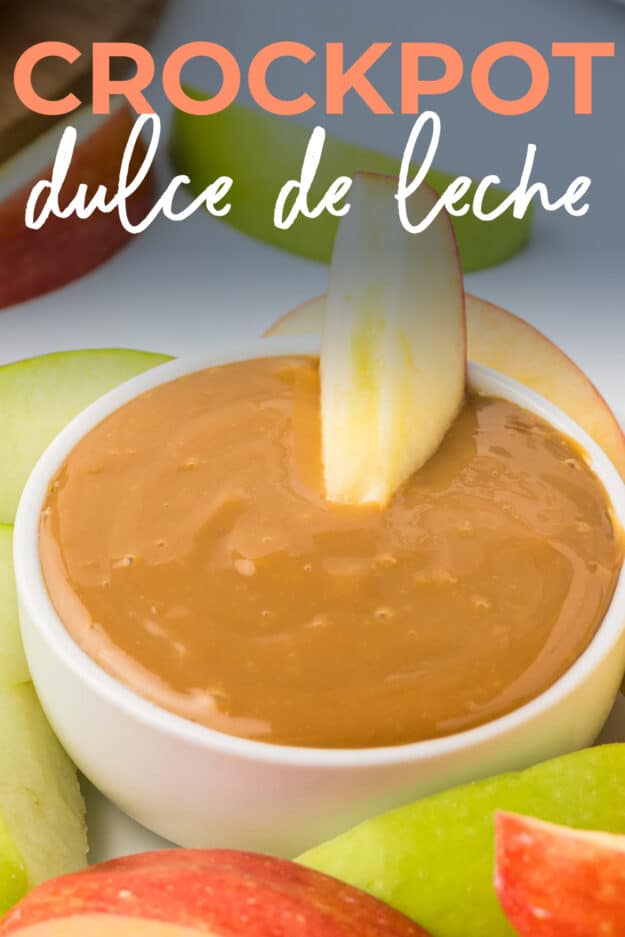 Apple dipped in small bowl of dulce de leche.