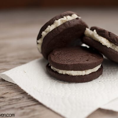 Three chocolate sandwich cookies leaning against each other on a folded napkin.