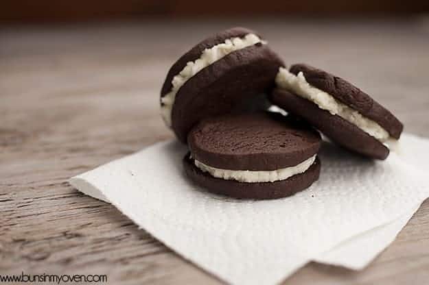 Three chocolate sandwich cookies leaning against each other on a folded napkin.