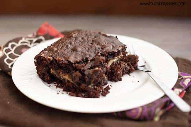 A close up of a gooey chocolate cake on a whtie plate