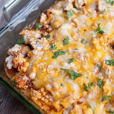 A close up of chicken tamale casserole in a clear glass baking pan.