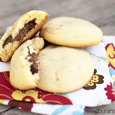 Three stacked up sugar cookies on a cloth napkin