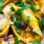 A close up of shell pasta with cilantro, beef, and cheese.