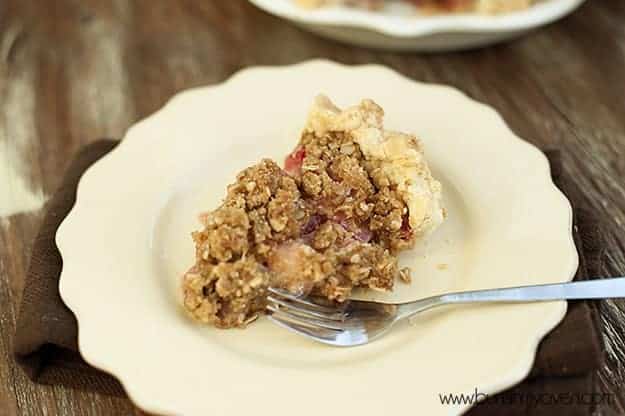 A plate of strawberry rhubarb pie with a fork on it 