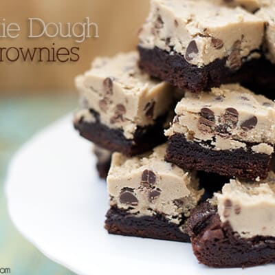 A closeup of stacked cookie dough brownies on a cake stand