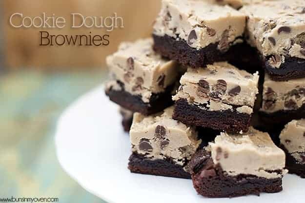 A closeup of stacked cookie dough brownies on a cake stand