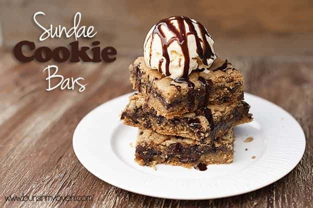 Three cookie bars topped with a scoop of ice cream on a white plate 