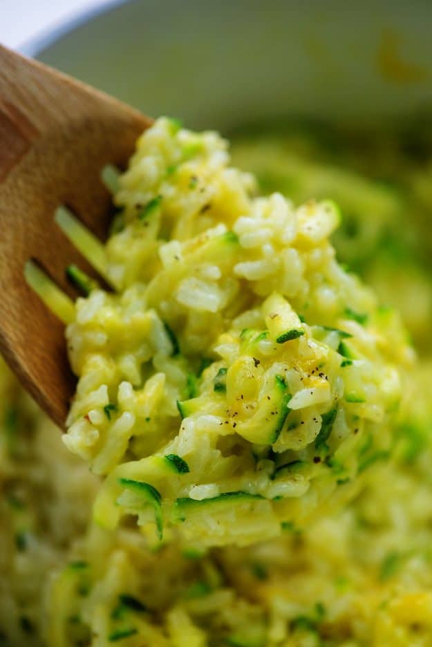 rice with cheese and zucchini on wooden spoon