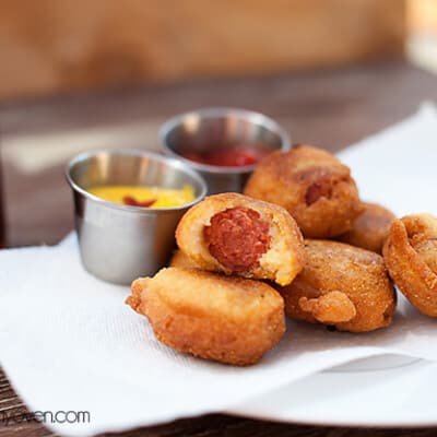 Corn dog bites on a plate with a bite taken out of one of them