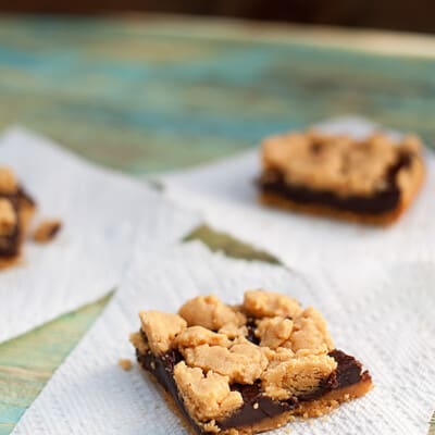 Three chocolate peanut butter bars on paper towels.