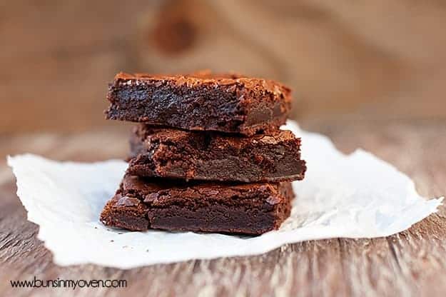 A close up of a side view of stacked up homemade brownies.