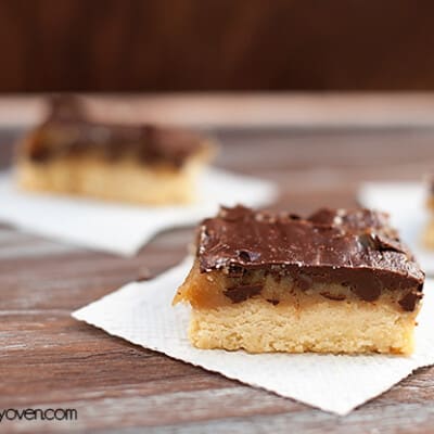 A close up of a shortbread bar topped with chocolate frosting.