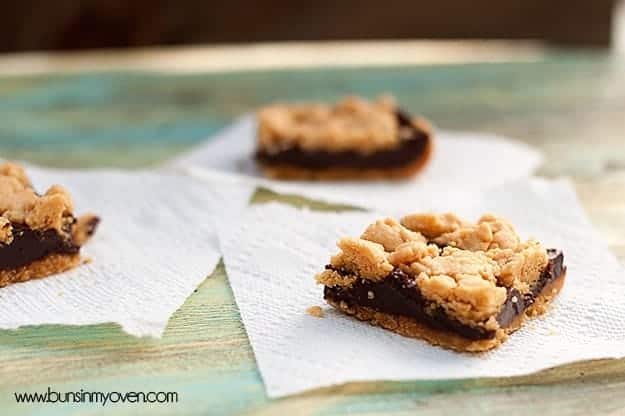A close up of three chocolate peanut butter bars on a table