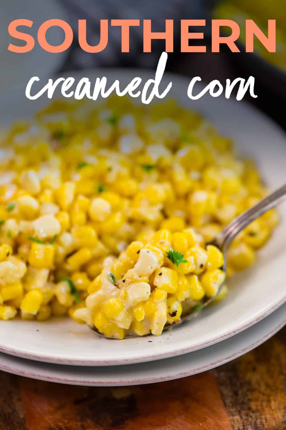 Spoonful of creamed corn recipe on plate.