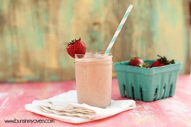 A strawberry milkshake in a glass jar on a folded cloth napkin