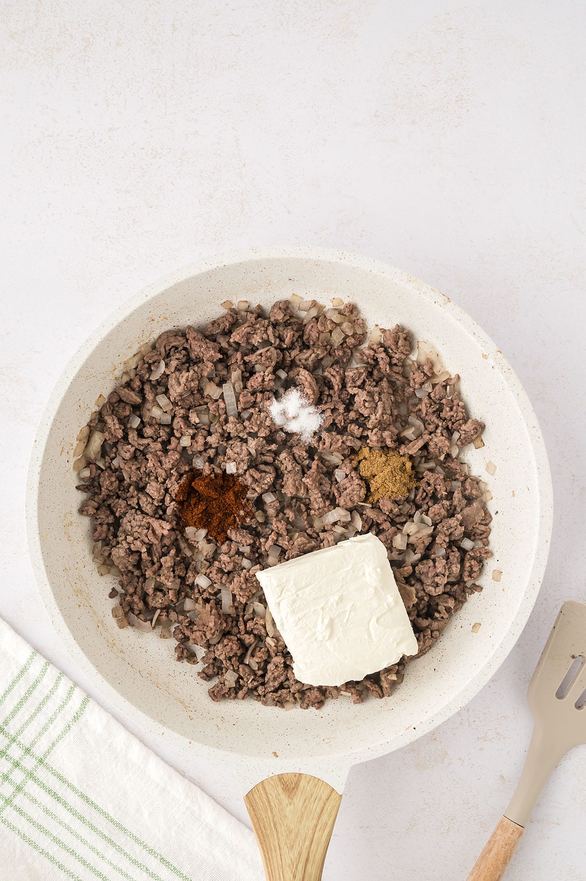 Ground beef with cream cheese and seasonings in skillet.