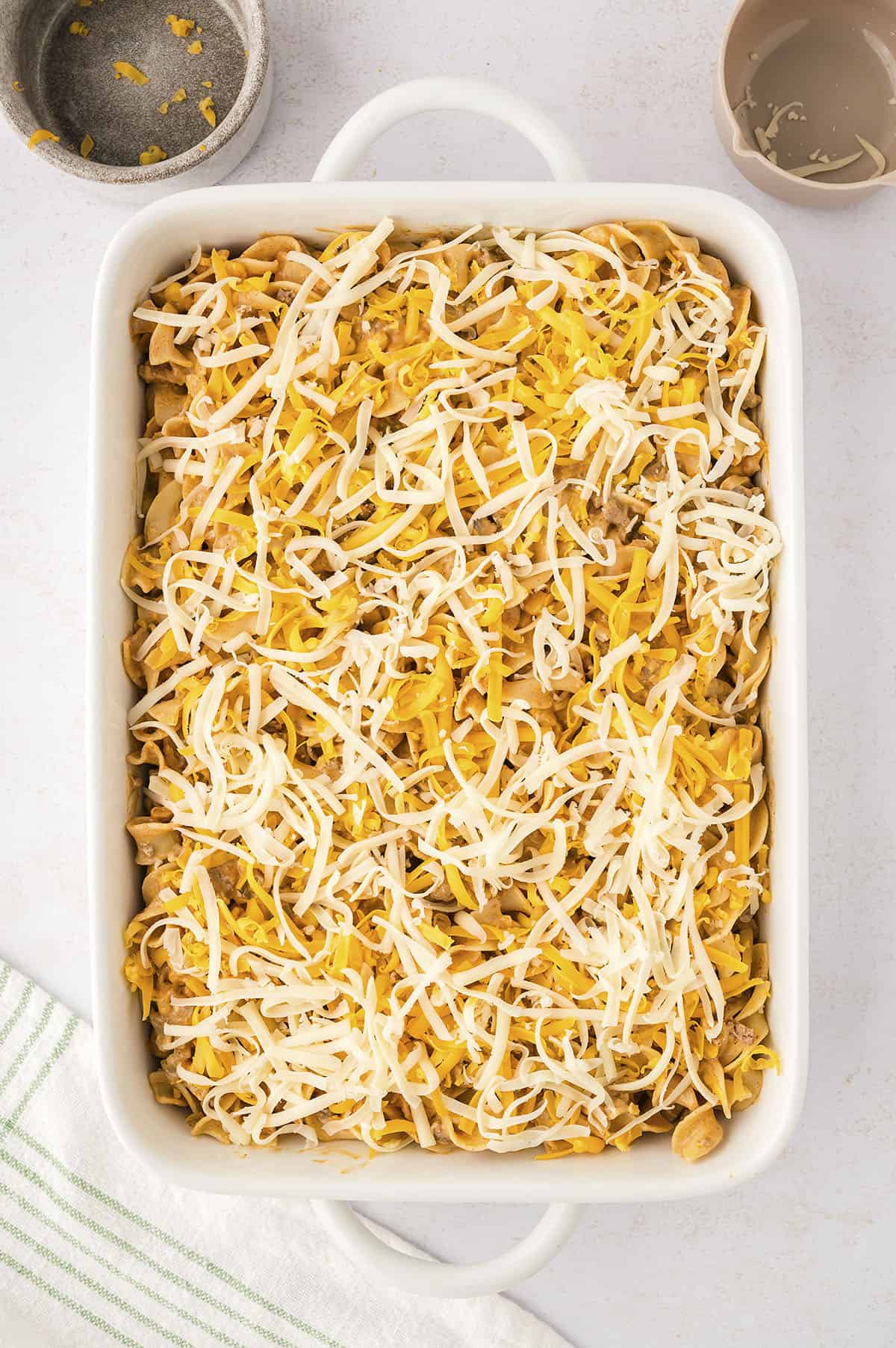 Enchilada casserole in baking dish topped with cheese.