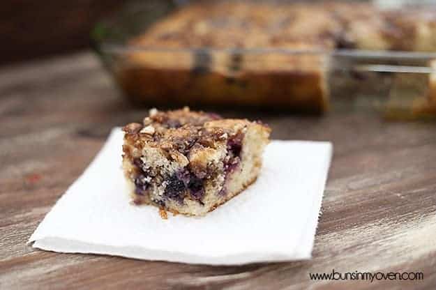 A square piece of blueberry honey bun cake up close on a napkin.