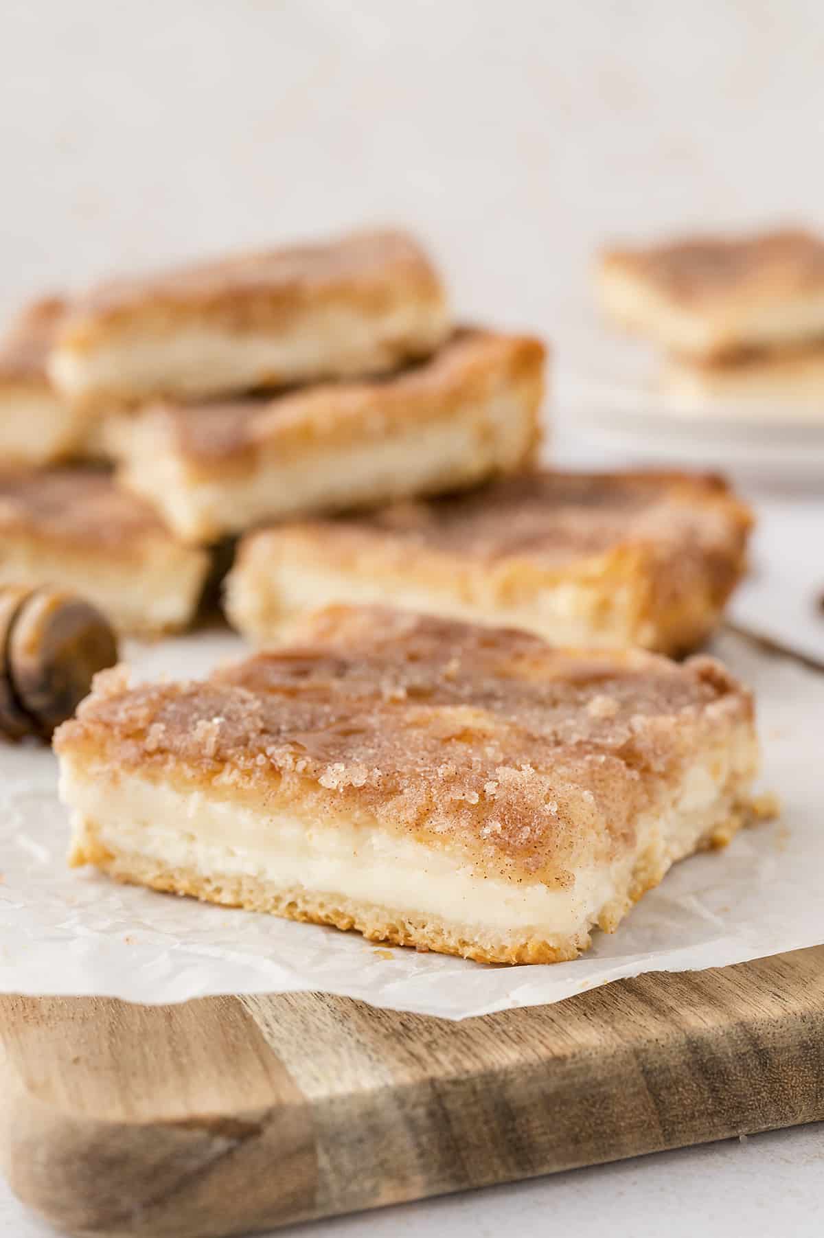 Mexican cheesecake bars on wooden board.