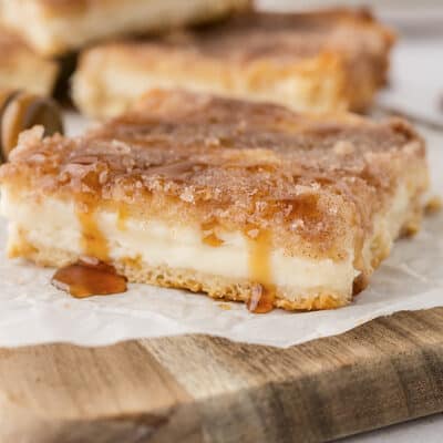 Slice of sopapilla cheesecake with honey drizzled over the top.