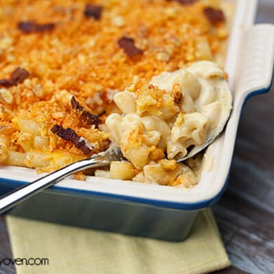 A pan of baked mac and cheese with a spoon in it.