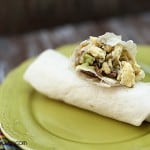 A couple of stacked breakfast burritos on a small plate.