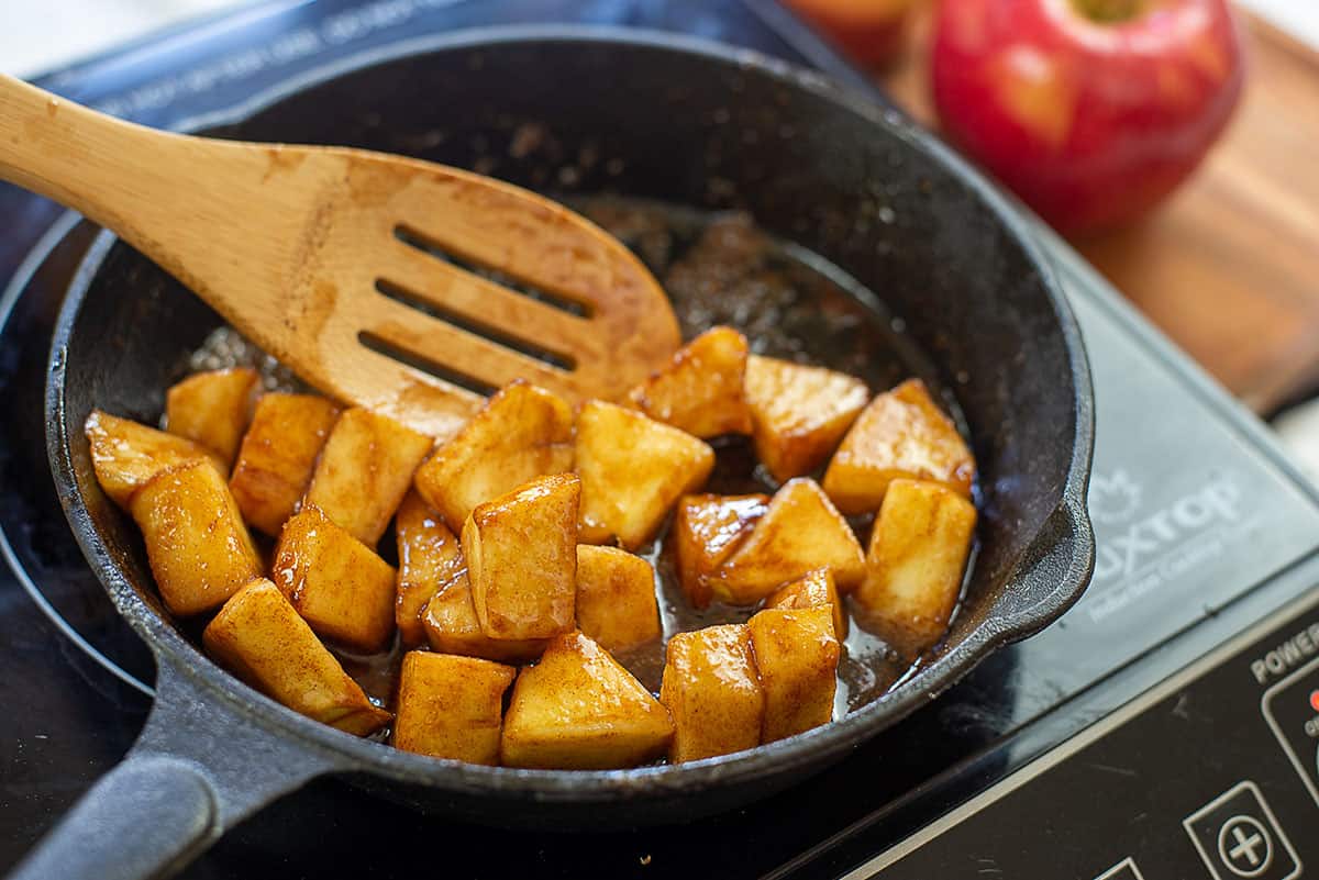 apples cooking in cast iron skillet.