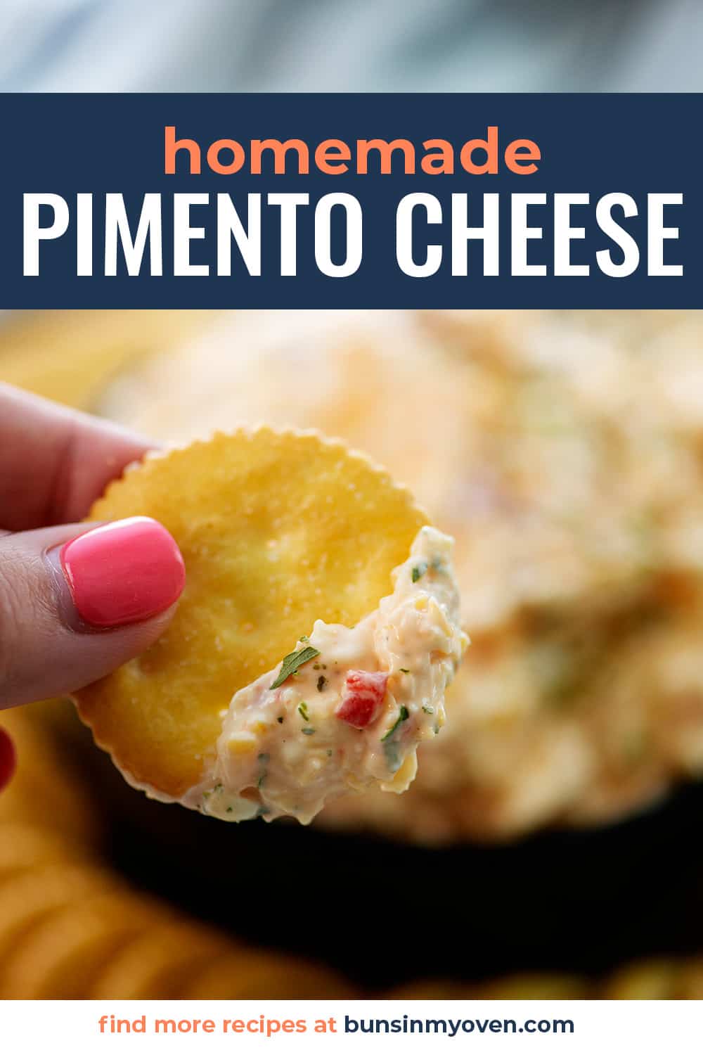 hand holding a cracker spread with pimento cheese.