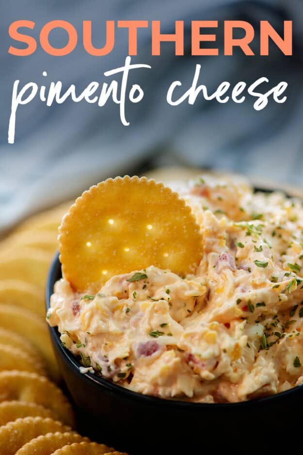 cracker dipped into bowl of pimento cheese.