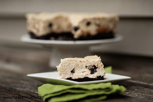 A close up of a piece of brownie cheesecake on a folded cloth napkin