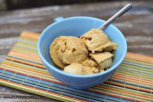 A few scoops of caramel ice cream and a spoon in a bowl